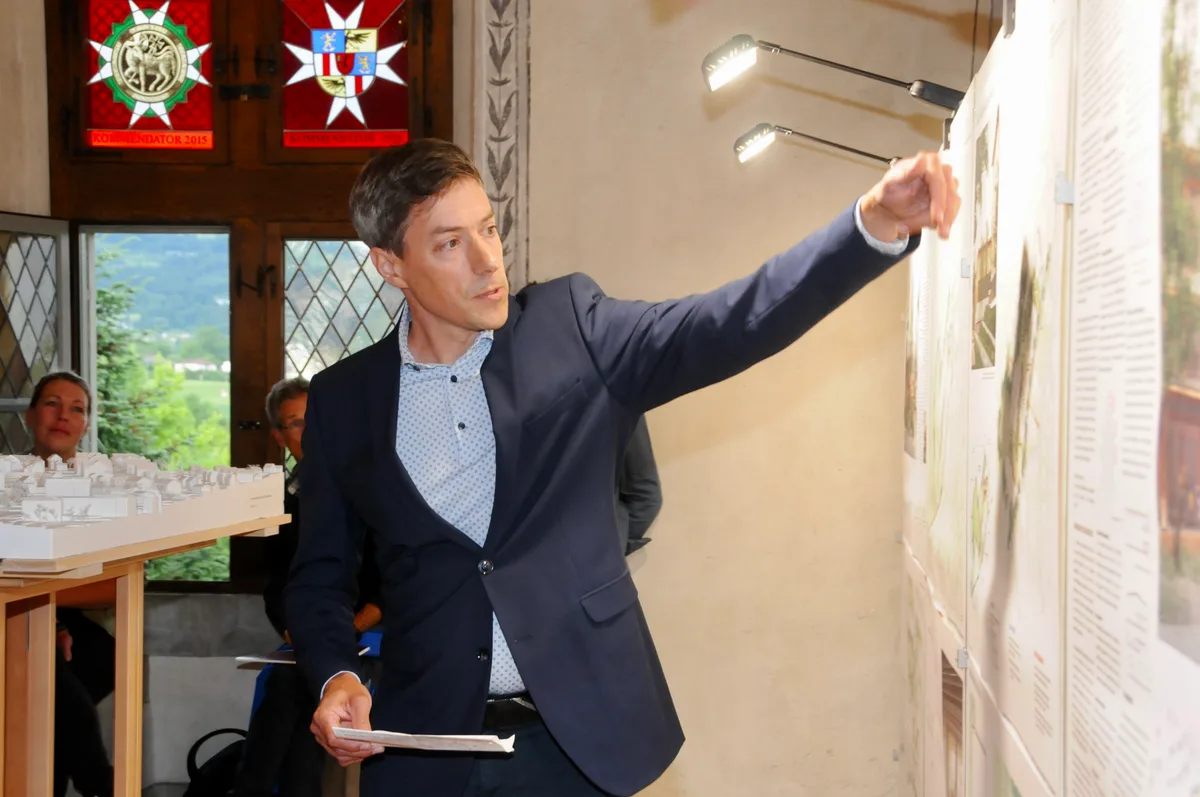 Man sieht den Gemeinderat Reto Frey auf die Visualisierung zeigen.
